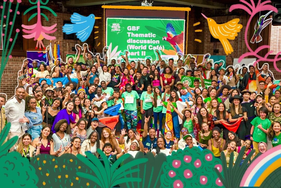 A cheerful group of people posing in front of a lively, colorful backdrop for a photograph.